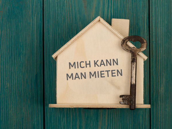 Kleines gebasteltes Holzhaus mit Schlüssel - Darauf der Spruch: Mich kann man mieten